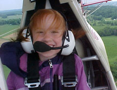 Young pilot in a headset at the controls of the Elizabeth Challenger